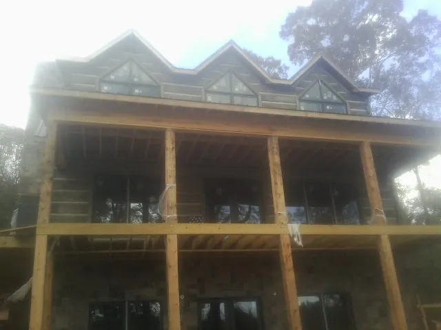 Dormers and porch framing on a large log home under construction — Roof Coating work by our crew in Scott Bar